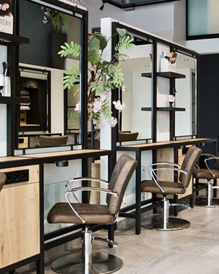 Het ruime, industrieel-stijlvolle interieur van Mienis Kapsalon in Delft